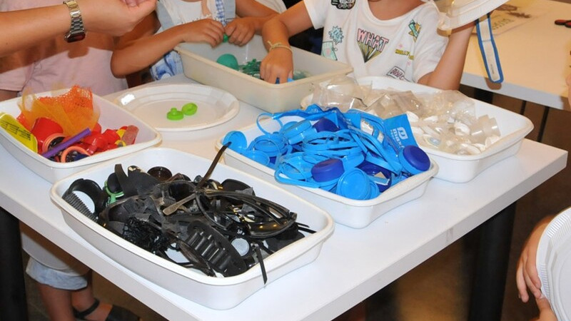 nens reciclant plàstics